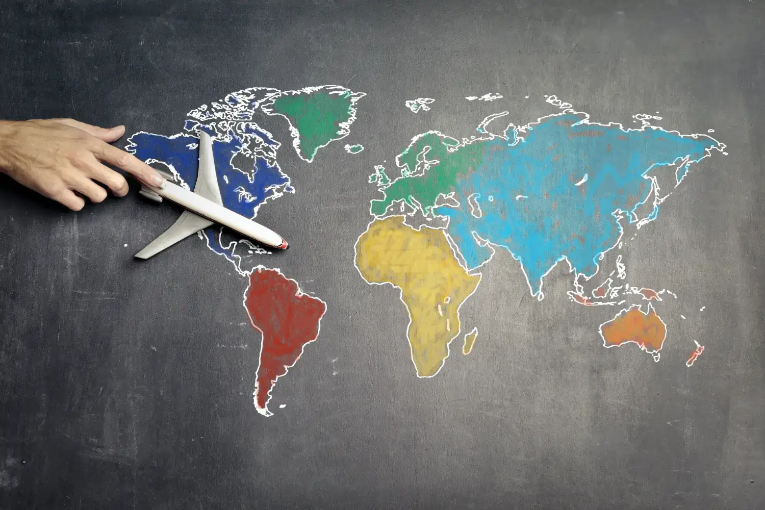 A world map with a plastic toy plane